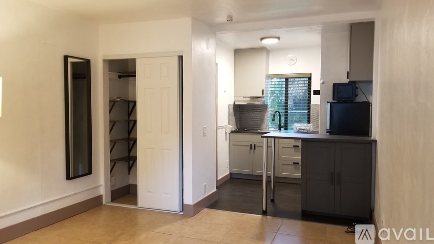 A kitchen with a white door and a counter with a microwave and a toaster.