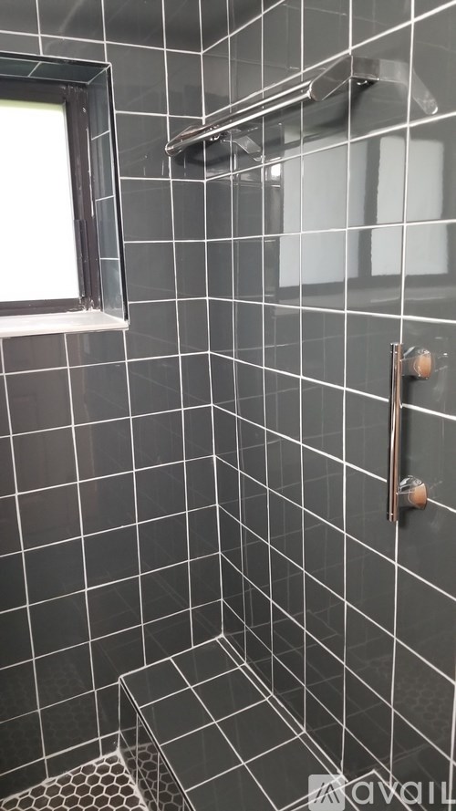 A tiled shower stall with a glass door.