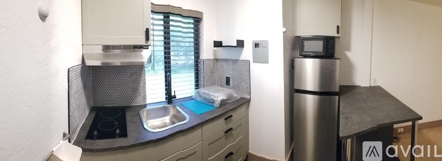 A kitchen with a sink and a refrigerator.