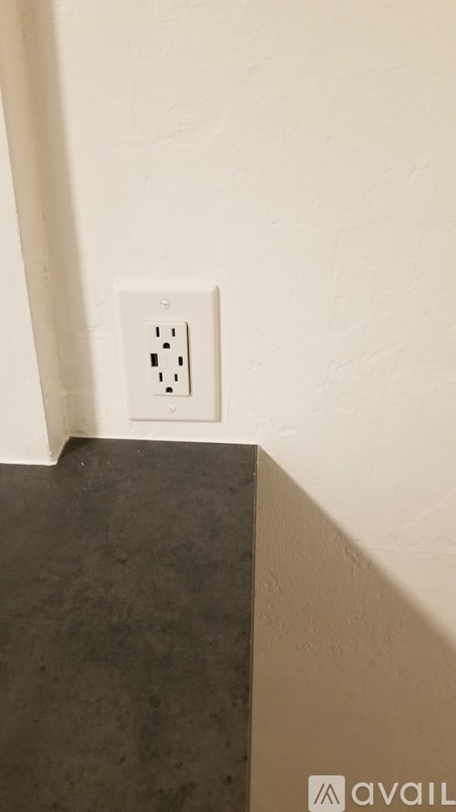 A white electrical outlet on a white wall.