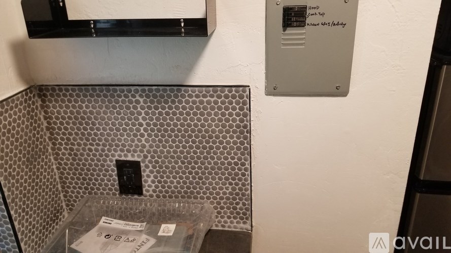 A wall with a tiled section and a metal plate with writing on it.