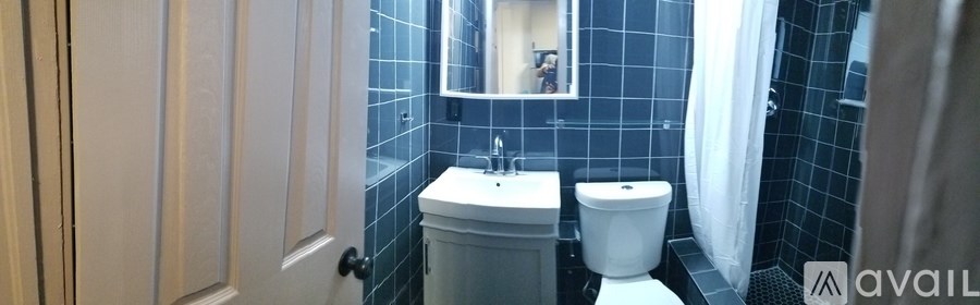 A bathroom with a sink, toilet and mirror.