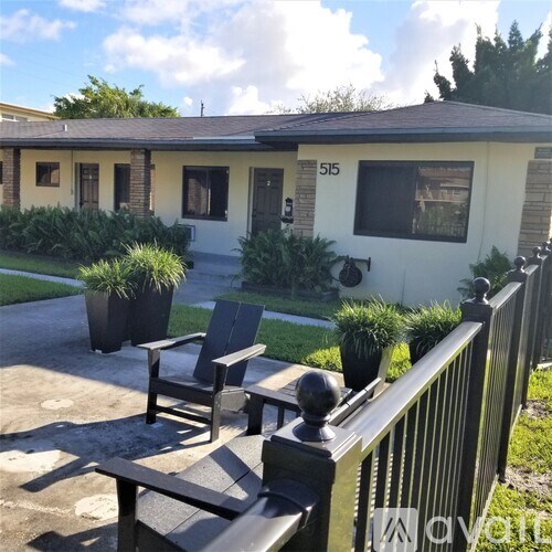 A house numbered 515 with a black fence and a small garden.