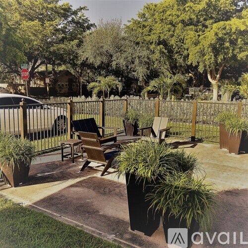 A patio with a table and chairs surrounded by a fence and trees.