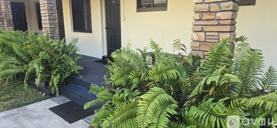 A house with a black door and a stone pillar.