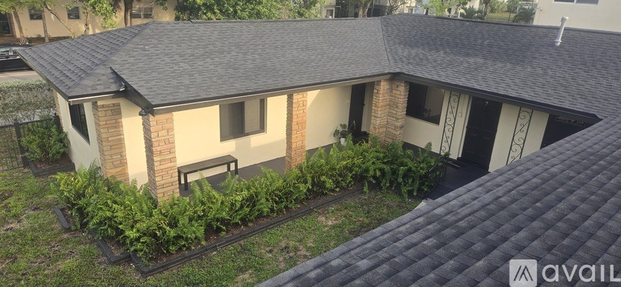 A house with a grey roof and a garden in front.