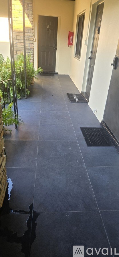 A hallway with a black mat on the floor.