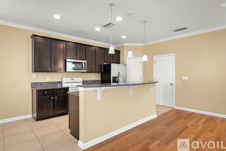 A kitchen with brown cabinets and a countertop is available.