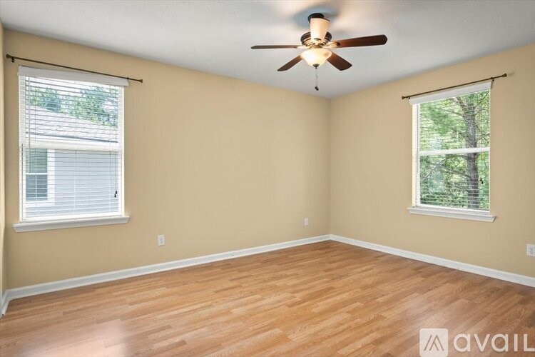 A room with wooden floors and a ceiling fan.