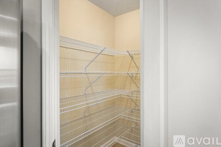 Empty silver fridge with shelves inside.