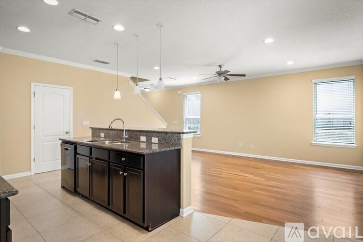 A kitchen with a black countertop and a ceiling fan.