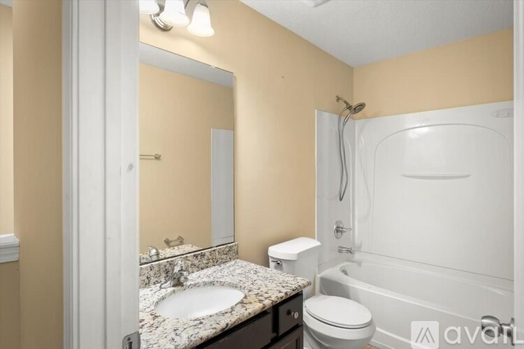 A bathroom with a sink, toilet, and bathtub.
