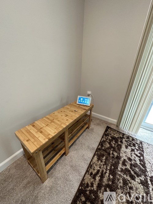 A wooden bench with a tablet on it in a room.