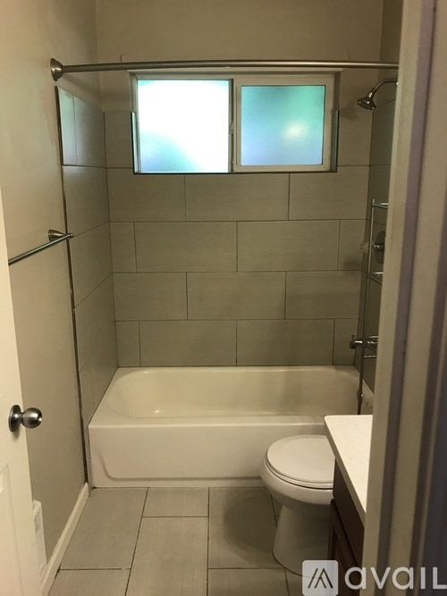A bathroom with a white tub and toilet.