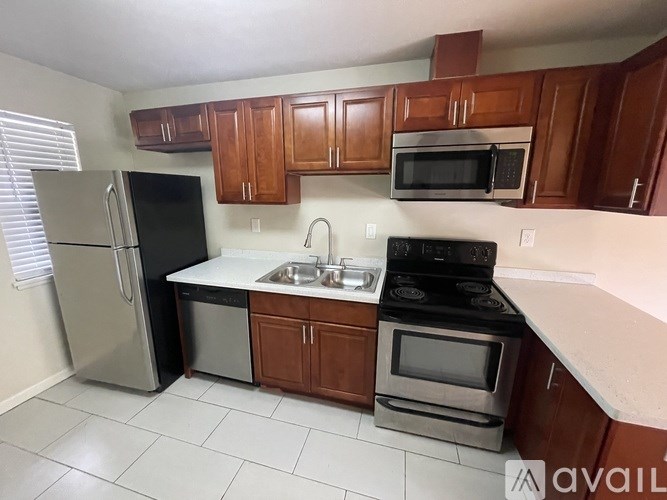 A kitchen with wooden cabinets and black appliances.