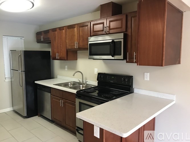 A kitchen with brown cabinets and a black stove top oven.