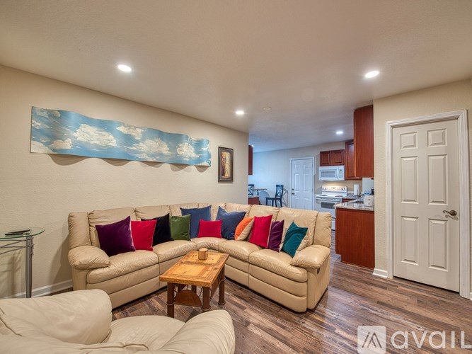 A living room with a beige couch and a wooden coffee table.