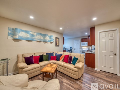 A living room with a beige couch and a wooden coffee table.
