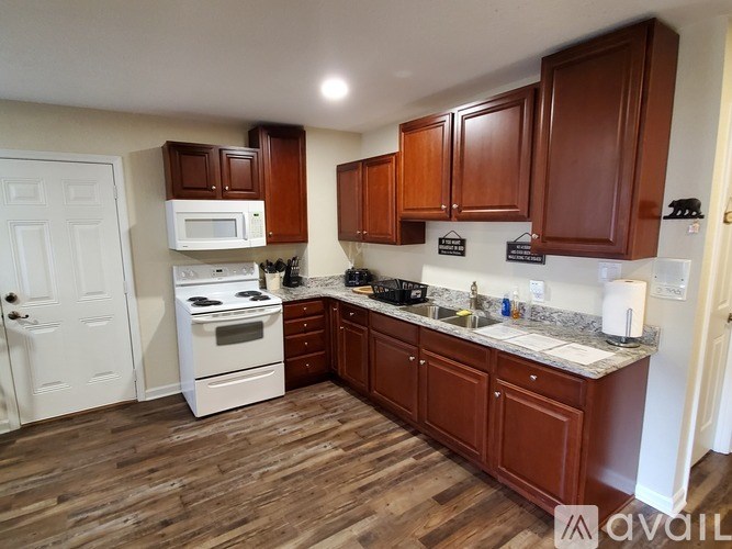 A kitchen with white appliances and wooden cabinets.