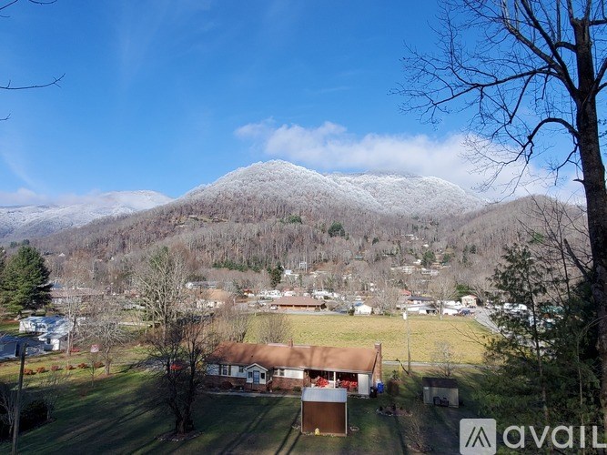 A mountain covered in snow with houses in the foreground.