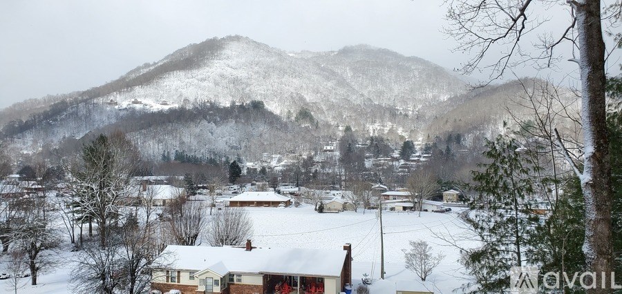 A snowy landscape with houses and trees.
