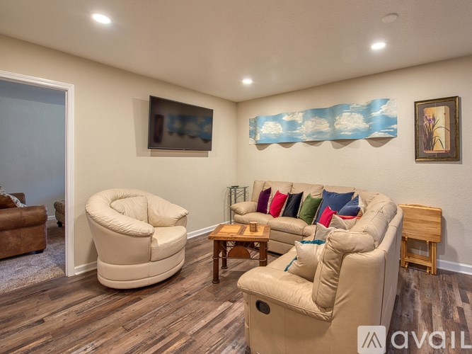 A living room with a white couch and a white chair.