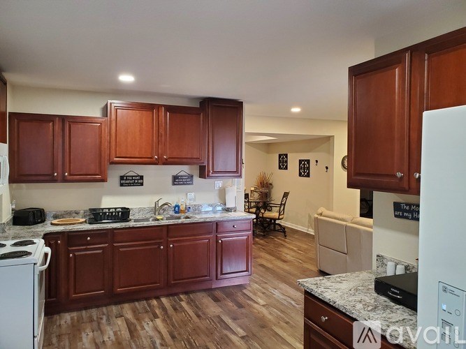 A kitchen with brown cabinets and a white fridge.