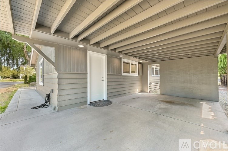 A house with a grey siding and a white door is available for rent.