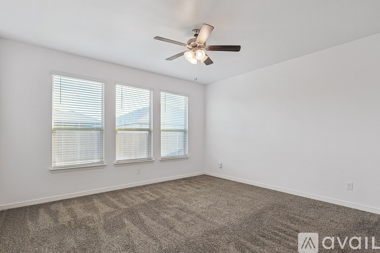 A room with a ceiling fan and carpeted floor.