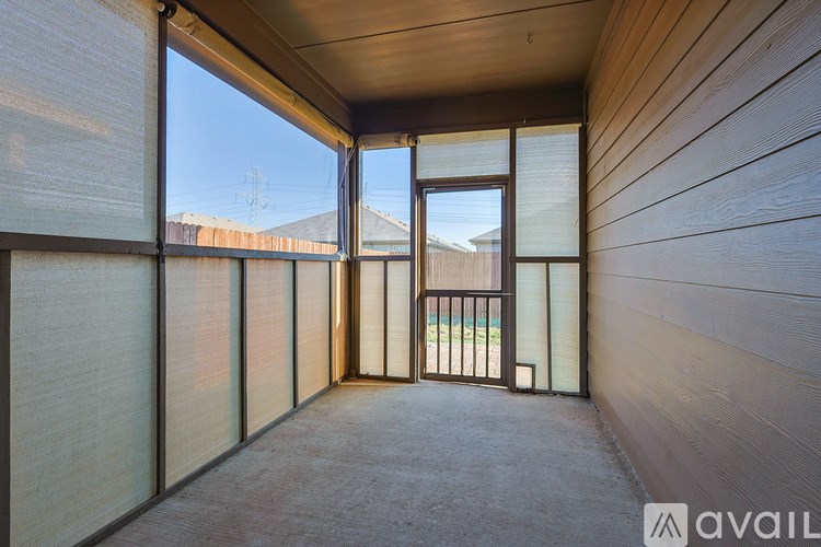 A balcony with a view of a fence and a building in the distance.