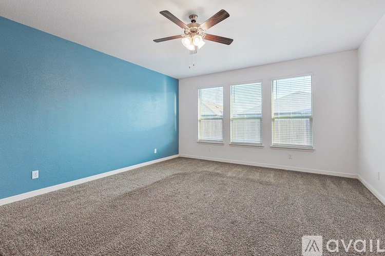 A room with a ceiling fan and carpeted floor.