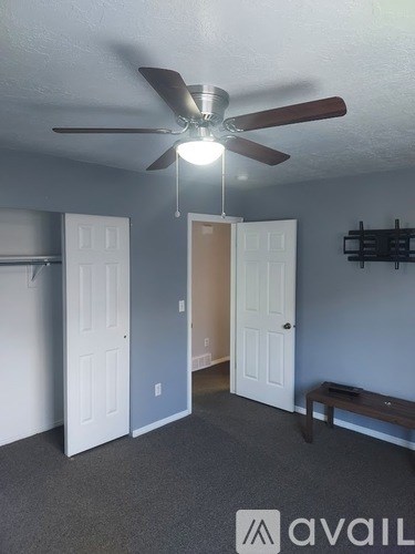 A room with a ceiling fan and two doors.