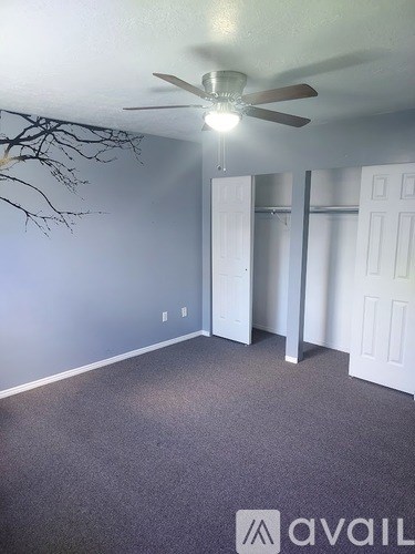 A room with a ceiling fan and a carpeted floor.