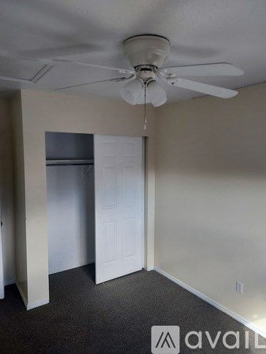 A room with a ceiling fan and a door.