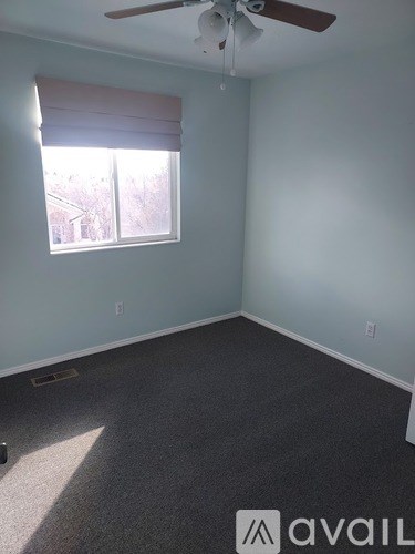 A room with a window and a ceiling fan.