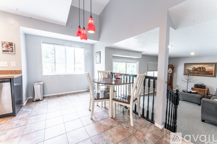 A dining room with a table and chairs.