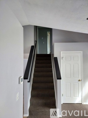 A staircase with a white door at the top.