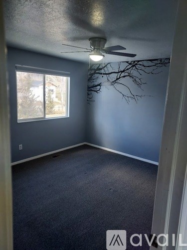 A room with a ceiling fan and a window.