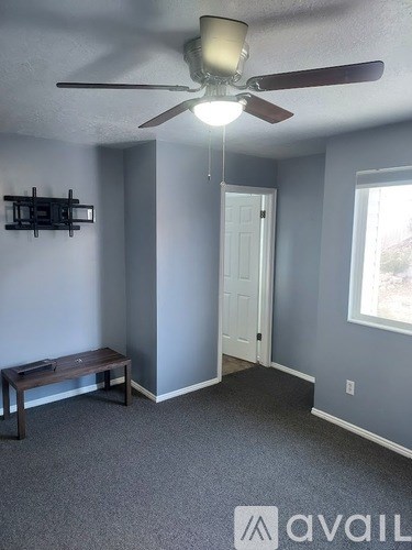 A room with a ceiling fan and a bench.