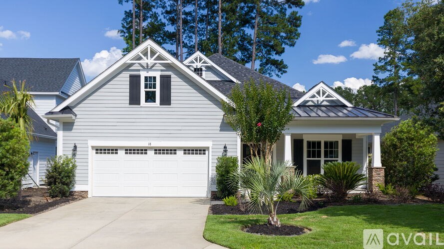 A house with a garage and a driveway in front of it.