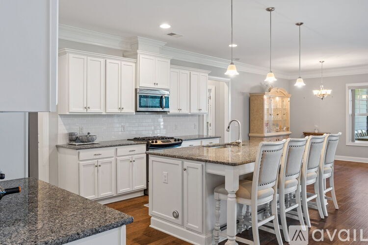 A kitchen with white cabinets and a granite countertop.