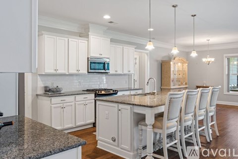 A kitchen with white cabinets and a granite countertop.
