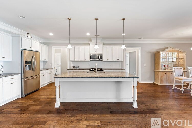 A kitchen with white cabinets and a wooden island.