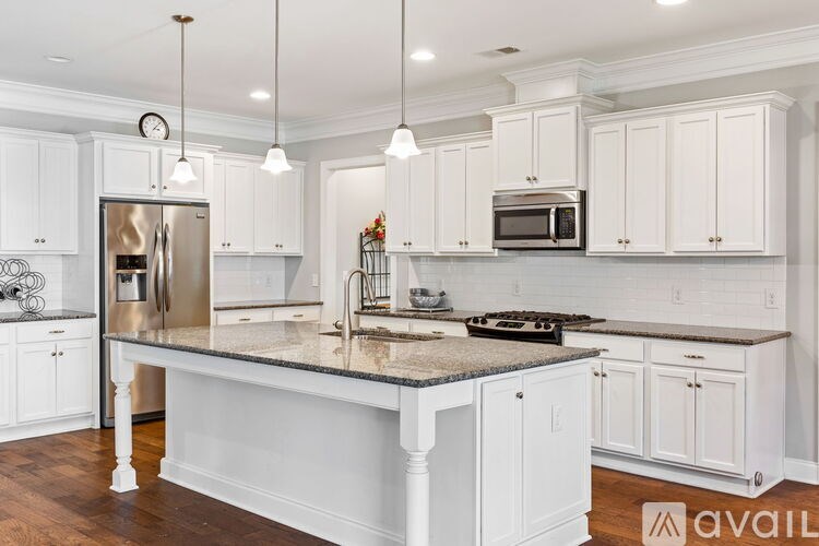 A kitchen with white cabinets and a granite countertop.