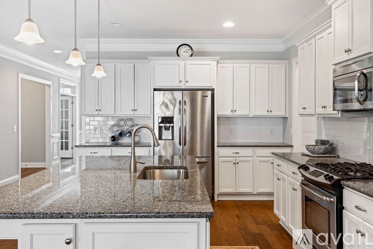 A kitchen with white cabinets and a granite countertop.