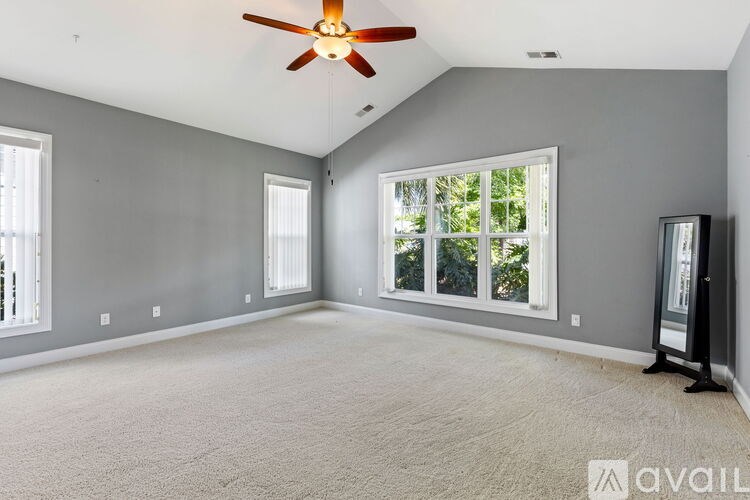 A room with a ceiling fan and a carpeted floor.