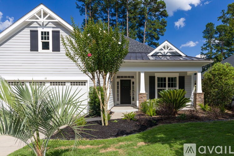 A house with a front yard and a tree in the front.
