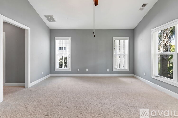 A spacious room with grey walls and carpeted floor.