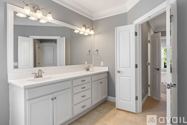 A bathroom with a vanity, mirror, and lights.