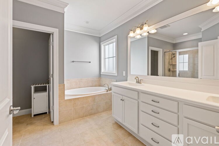A bathroom with a tub, sink, and mirror.